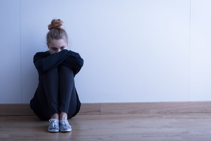 person sitting against a wall