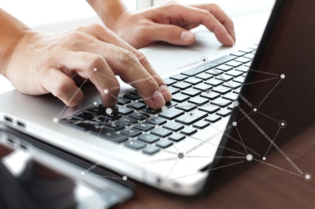 Close up of business man hand working on laptop computer with social network diagram on wooden desk as concept.jpeg