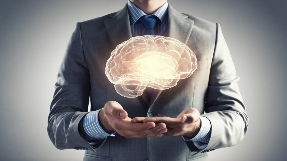 Close up of businessman holding digital image of brain in palm