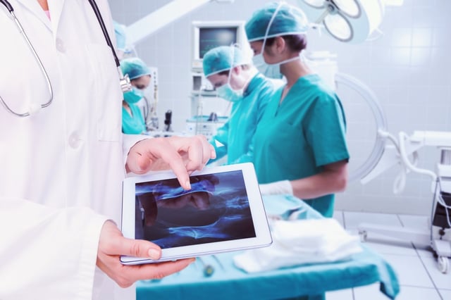 Composite image of doctor looking at xray on tablet.jpeg