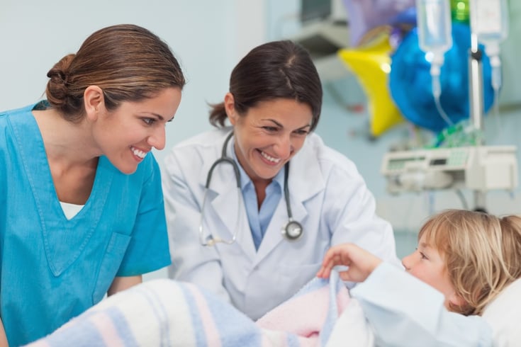 Doctor and nurse engaging with a young patient in hospital ward