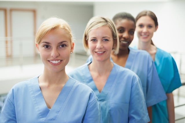 Female nurse looking at camera in hospital hallway.jpeg