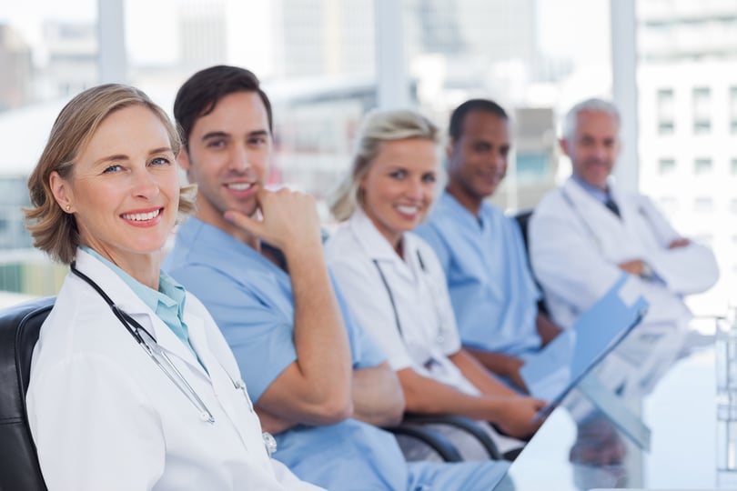 Medical team sitting in row and looking at the camera