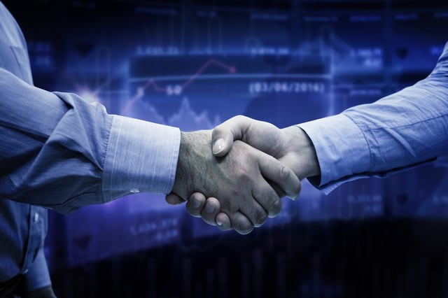 Men shaking hands against stocks and shares