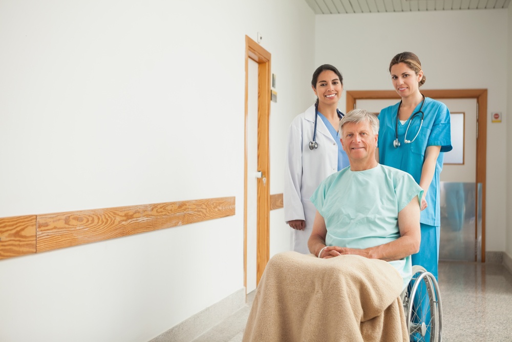 Patient in a wheelchair next to nurses in hospital