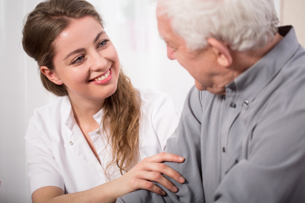 Picture of smiling nurse assisting senior man-1