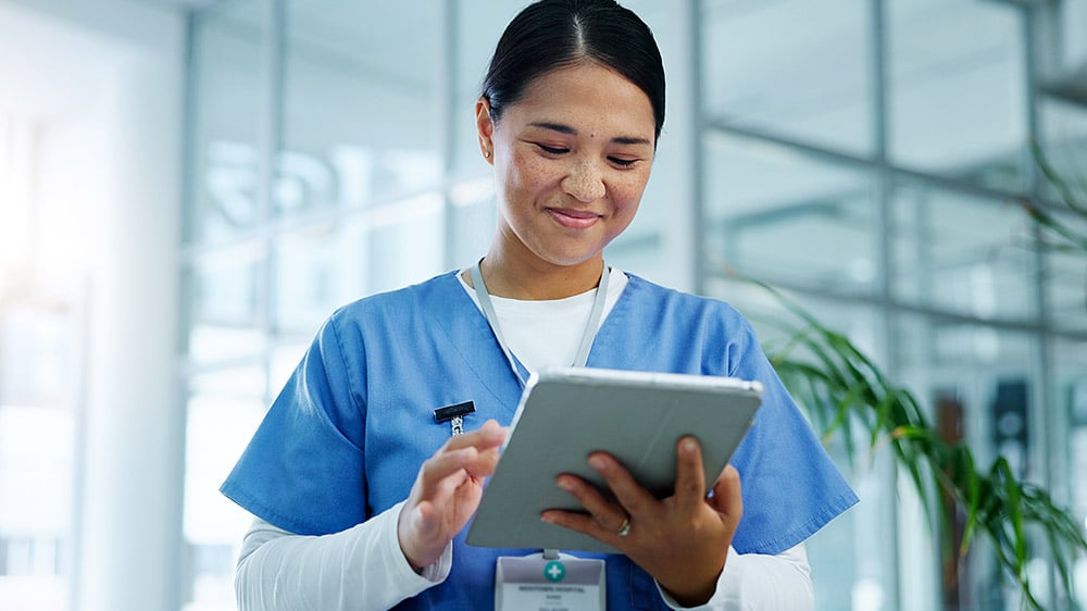 Smiling nurse using a tablet